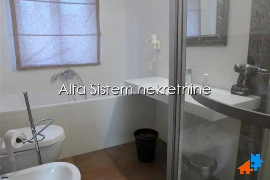 Bathroom equipped with a bathtub, washbasin, toilet, and shower cabin.