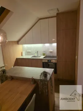 Modern kitchen with built-in cabinetry and a dining table. - image 3