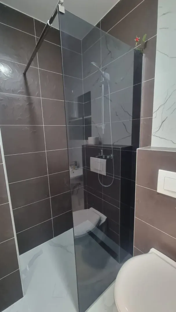 Modernly equipped bathroom with a walk-in shower.