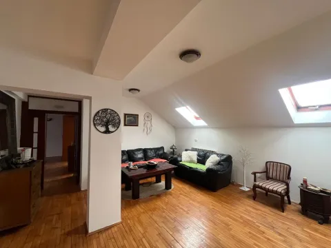 Potkrovni dnevni boravak sa garniturom za sedenje i drvenim podom. - image 3