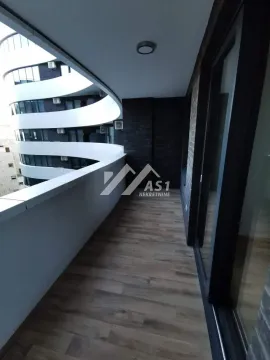 Natkriveni balkon sa drvenim podom i pogledom na zgradu. - image 2
