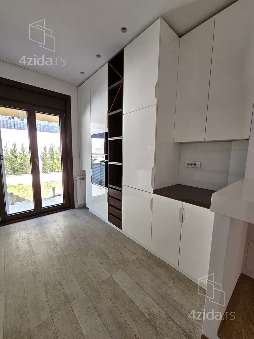 Kitchen with high-gloss white cabinets and a built-in oven.