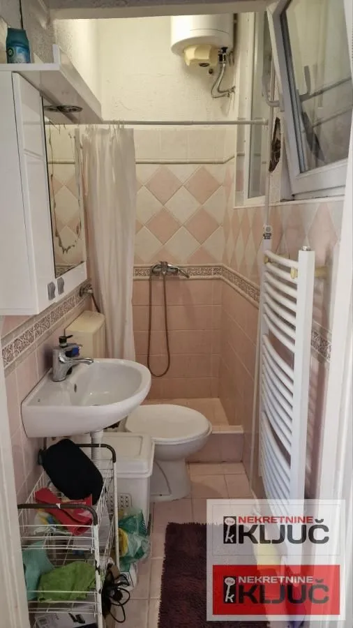 Manje kupatilo sa tuš kabinom, umivaonikom i wc šoljom.