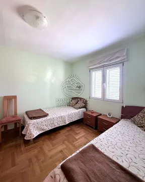 Spavaća soba sa dva singl kreveta i drvenim podom. - image 5