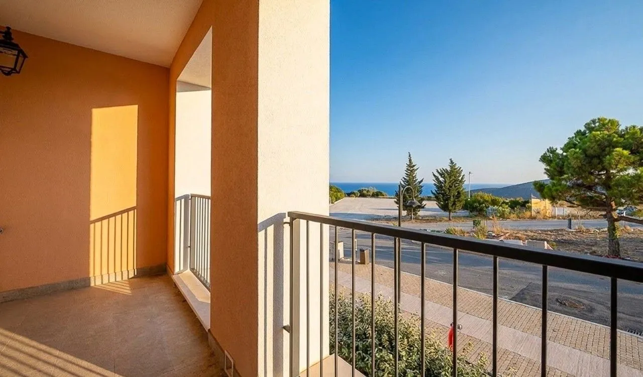 Natkriveni balkon sa metalnom ogradom i pogledom na okolinu i more.