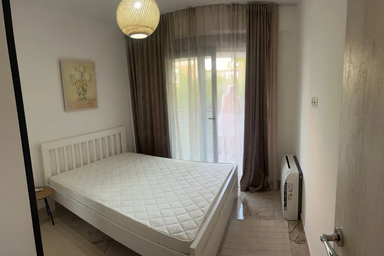 Bright bedroom with a double bed and balcony access.