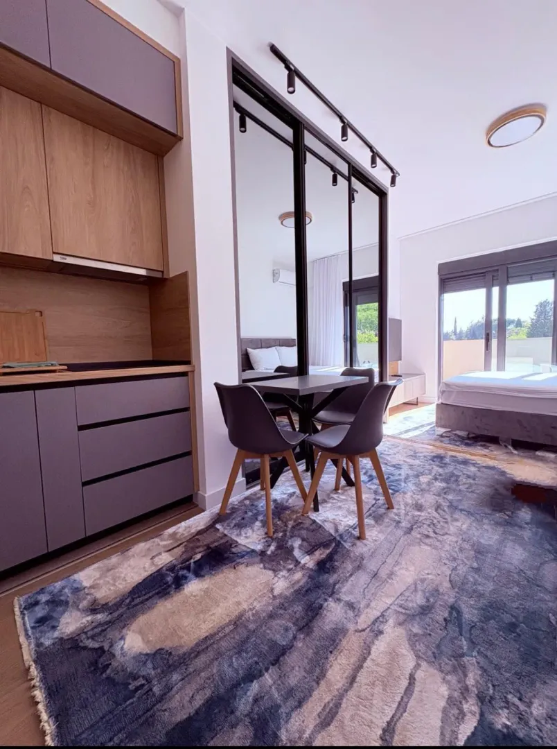Modern kitchen with a dining table and a view of the bedroom.