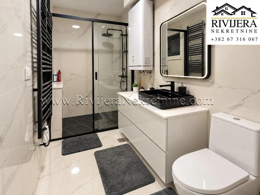 Modern bathroom with a walk-in shower, washbasin, and toilet.