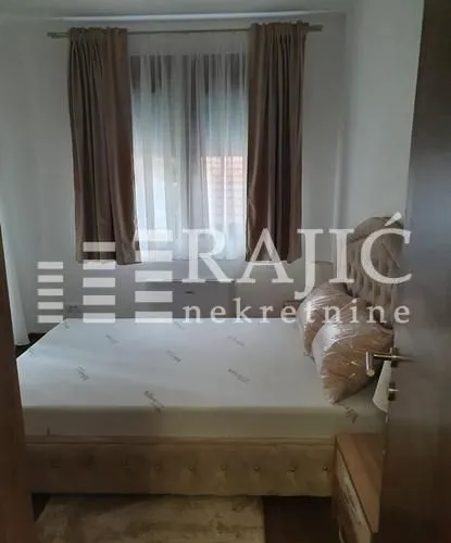 Furnished bedroom with a double bed and a window.