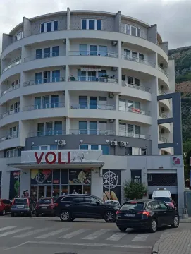 Exterior view of a multi-story residential and commercial building with a supermarket on the ground floor. - image 2