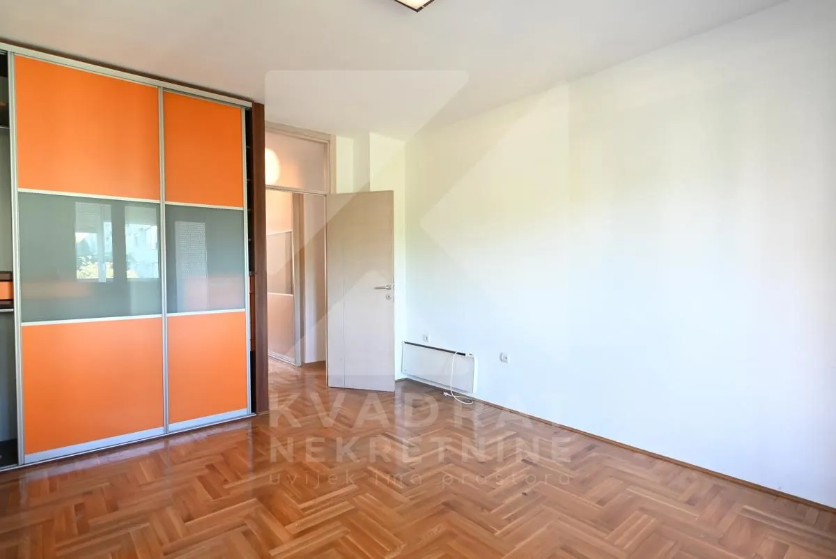 Empty bedroom with a built-in wardrobe and hardwood flooring.
