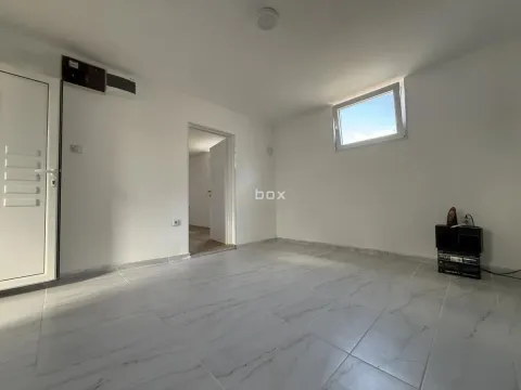 Empty room with white walls, tiled floor, and a small window. - image 11