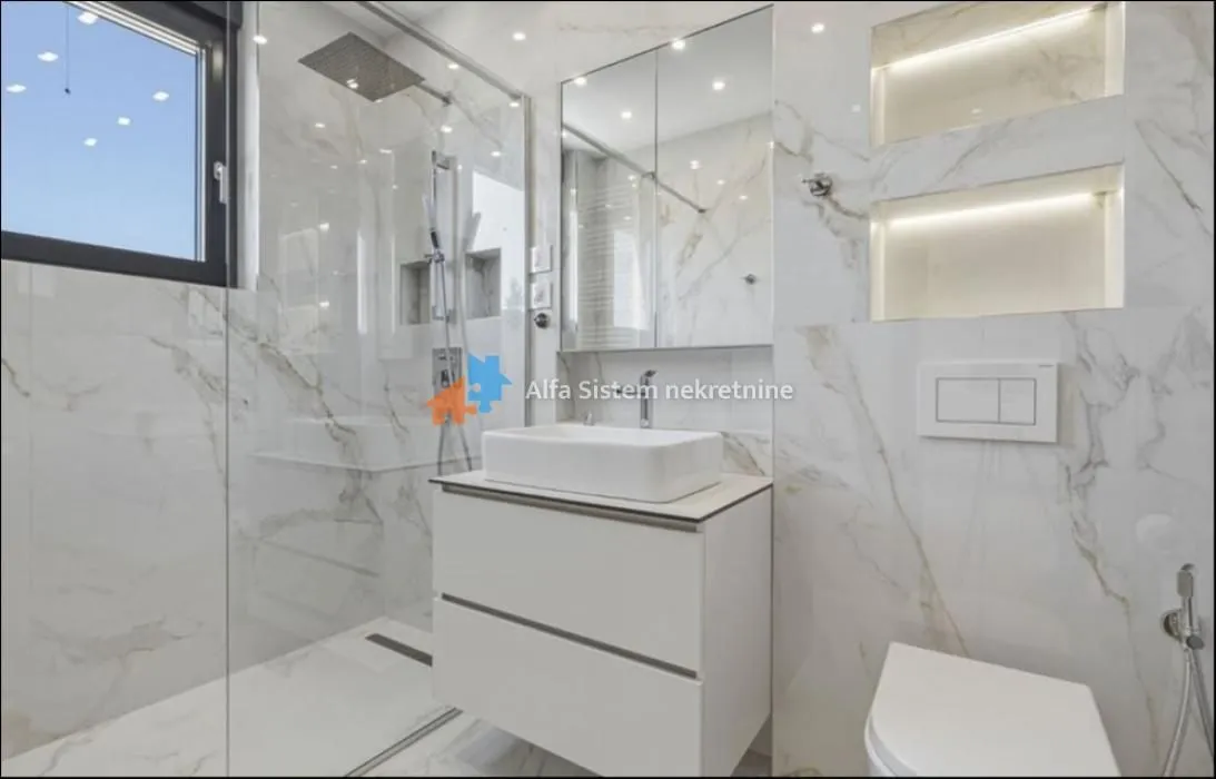 Modern bathroom with a walk-in shower and marble tiles.