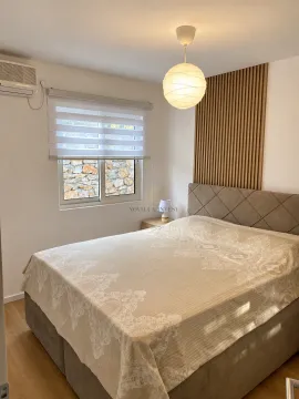 Furnished bedroom with a double bed, window, and wooden wall panel. - image 12