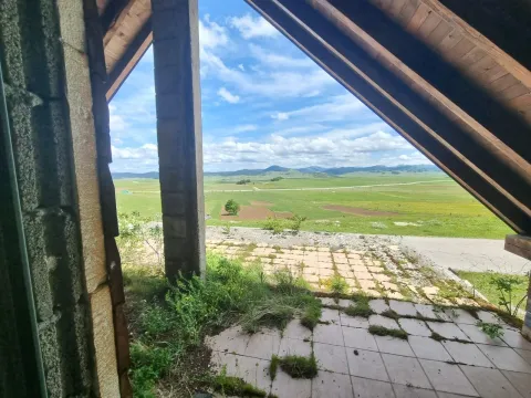 Pogled sa terase na prostrana zelena polja i brda u daljini. - image 15