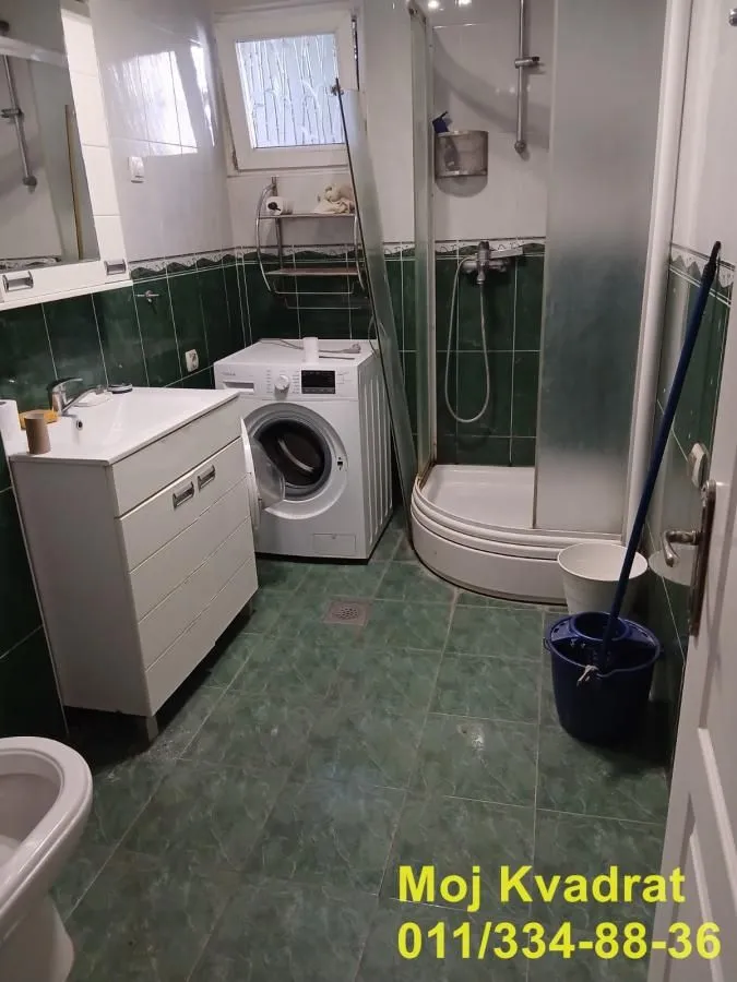 Bathroom with a shower cabin, washbasin, and washing machine.