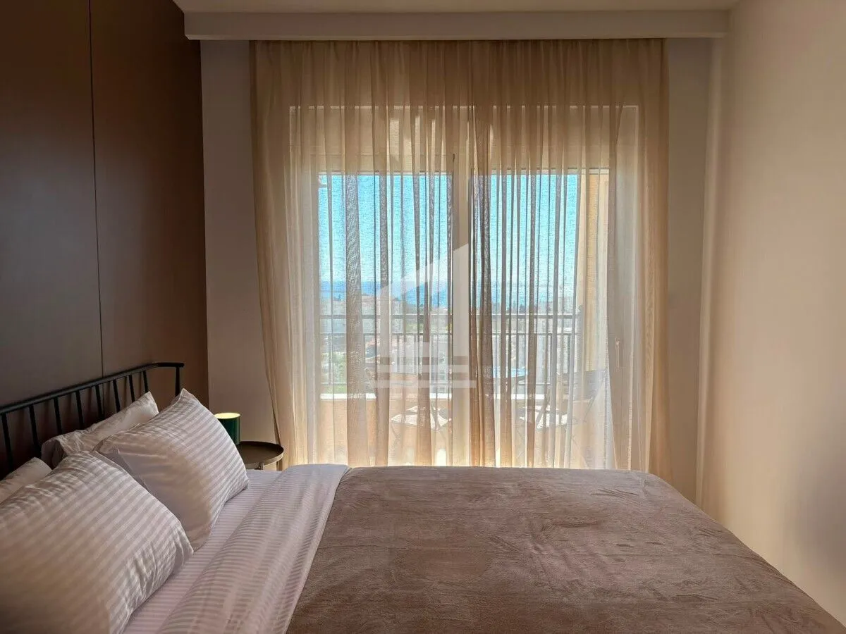 Bedroom with a double bed and access to a terrace with a sea view.