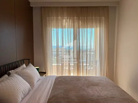 Bedroom with a double bed and access to a terrace with a sea view. - image 3