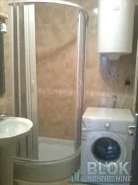 Bathroom with a shower cabin, washbasin, and washing machine. - image 3
