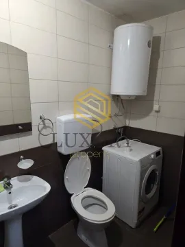 Small bathroom with a sink, toilet, water heater, and washing machine. - image 6