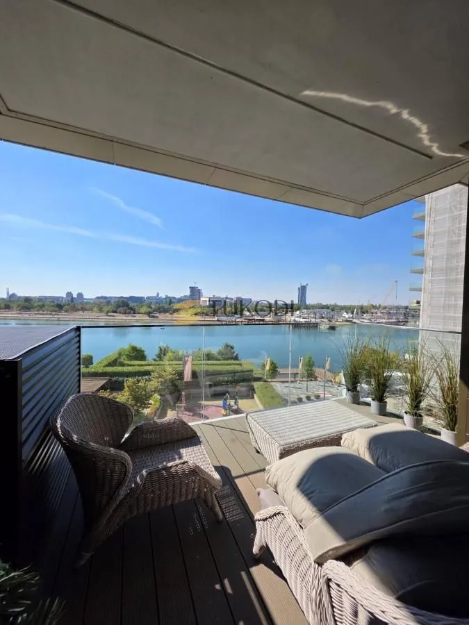 Furnished terrace with seating furniture and a river view.