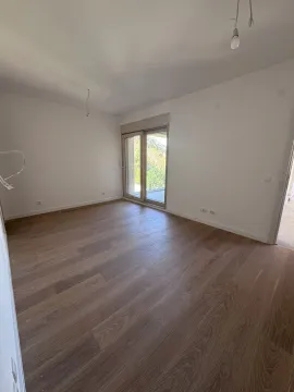 Prazna soba sa svijetlim zidovima, parketom i balkonskim vratima. - image 7