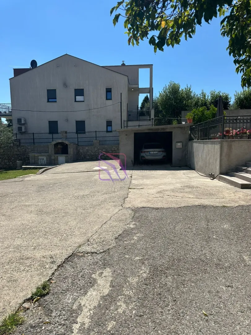 View of the courtyard and the house facade with a garage.