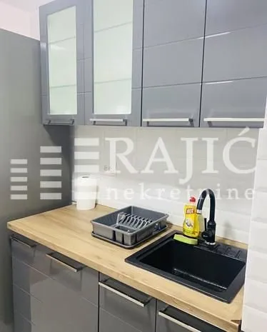 Modern kitchen with grey cabinets and a sink.