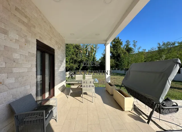 Covered terrace with outdoor seating and a view of the yard.