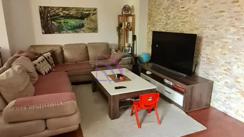 Dnevna soba sa ugaonom garniturom, stočićem i televizorom na zidu od ukrasnog kamena. - image 4