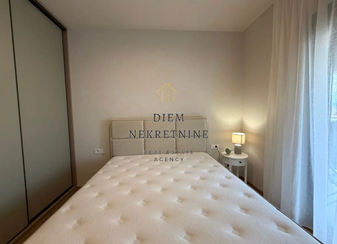 Modern bedroom with a double bed, wardrobe, and nightstand.