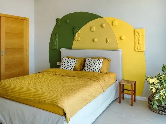 Modern bedroom with a double bed and a decorative wall.