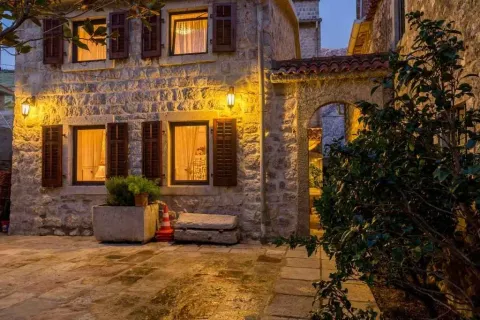 Kamena kuća tradicionalnog stila sa osvijetljenom fasadom i popločanim dvorištem. - image 4