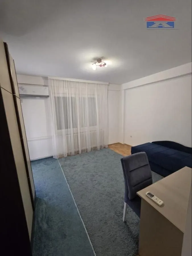 Smaller bedroom with a bed, desk, and rug.