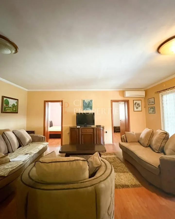 Living room with sofa set, coffee table, and television.