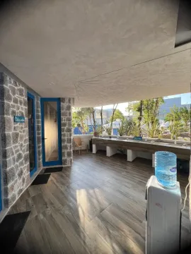 Covered terrace with stone walls, wooden counter and water dispenser. - image 9