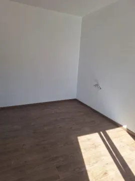 Empty room with white walls and a wooden floor. - image 11