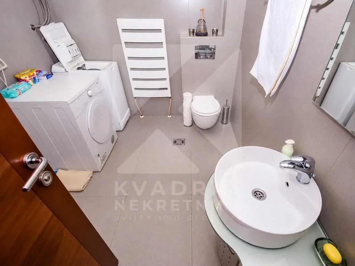 Modern bathroom with a washing machine, washbasin, and toilet.