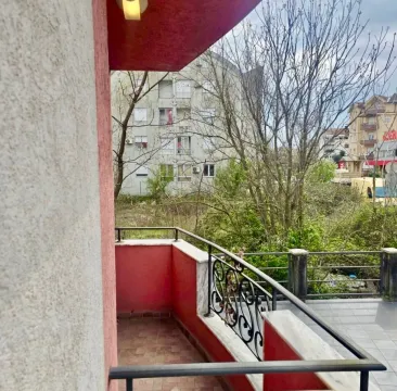 View from the balcony overlooking surrounding buildings and greenery. - image 10