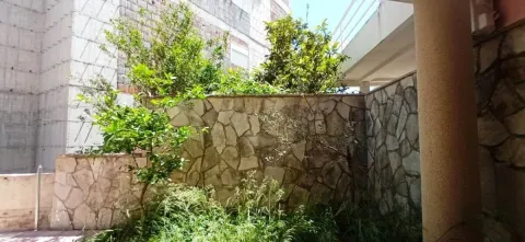 View of a fenced courtyard with a stone wall and greenery. - image 11