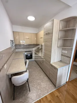 Kitchen equipped with wooden cabinets and a small dining table with chairs. - image 3