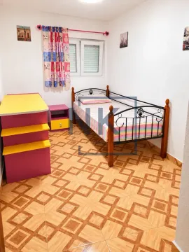 Children's bedroom with a bed, colorful bedding, and a chest of drawers. - image 13