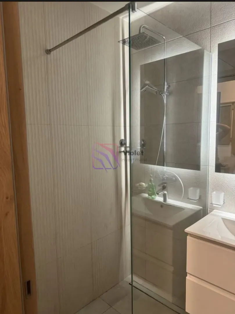 Modern bathroom with a walk-in shower and sink vanity.