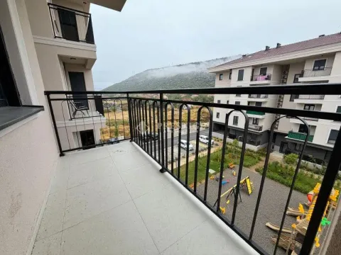View from the balcony overlooking surrounding buildings and a children's playground. - image 13