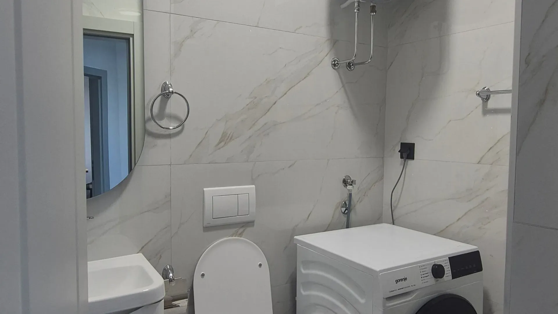 Moderne kupatilo sa veš mašinom, WC šoljom, umivaonikom i bojlerom.