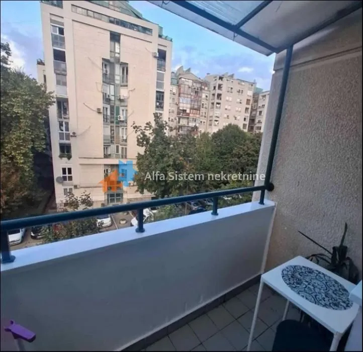 Small covered balcony with a view of surrounding buildings and the urban neighborhood.