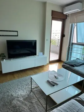 Dnevna soba sa televizorom, garniturom i izlazom na terasu. - image 3