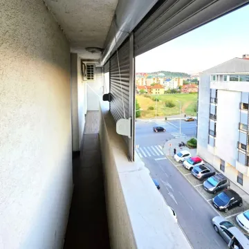 Long balcony with a view of the street and parking lot. - image 4