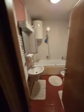 A simple bathroom featuring a bathtub, sink, and water heater. - image 14