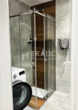 Modernly equipped bathroom with a shower cabin and washing machine. - image 6